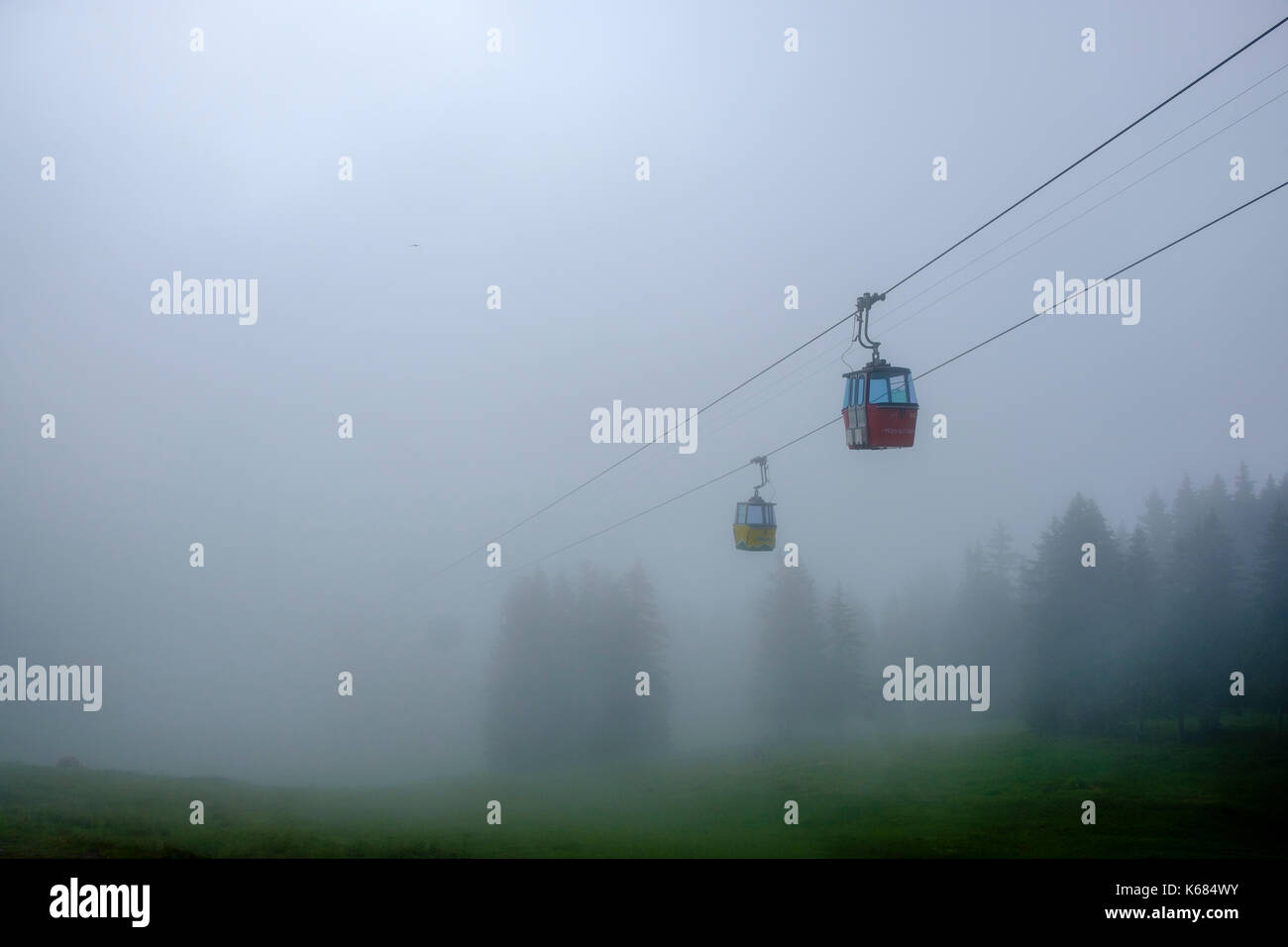 Two gondolas of the ropeway to Männlichen are coming out of the clouds Stock Photo