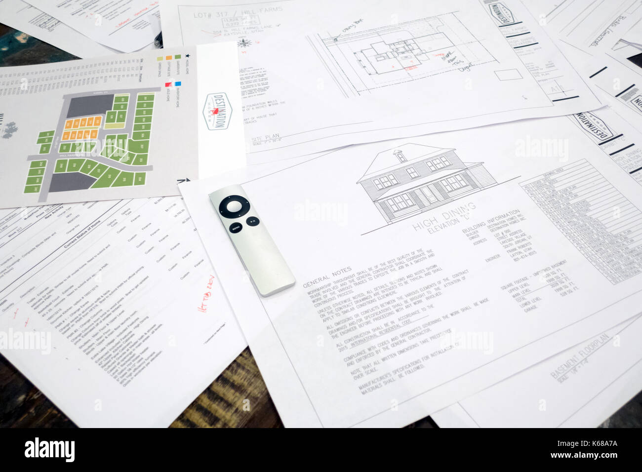 A pile of spread out floor plan and neighborhood plot papers and a