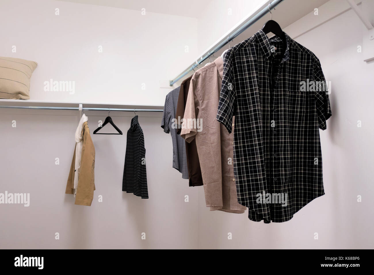 A walk-in closet full of men's short sleeved button up sleeves. Stock Photo