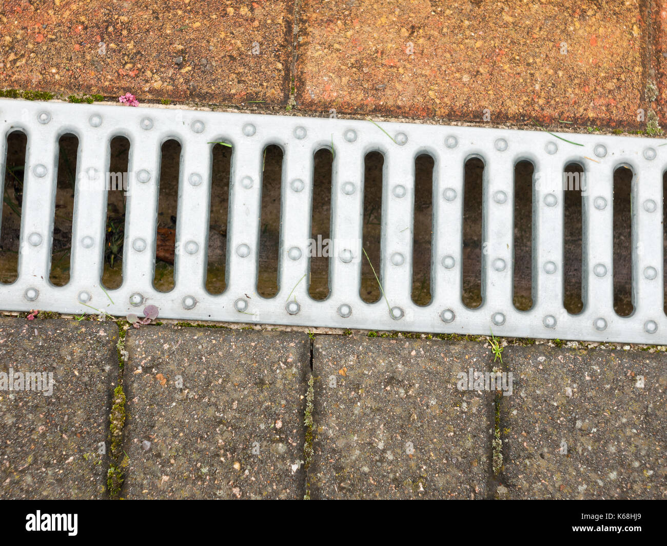 close up of metal grate on side of floor pavement; England; UK Stock Photo