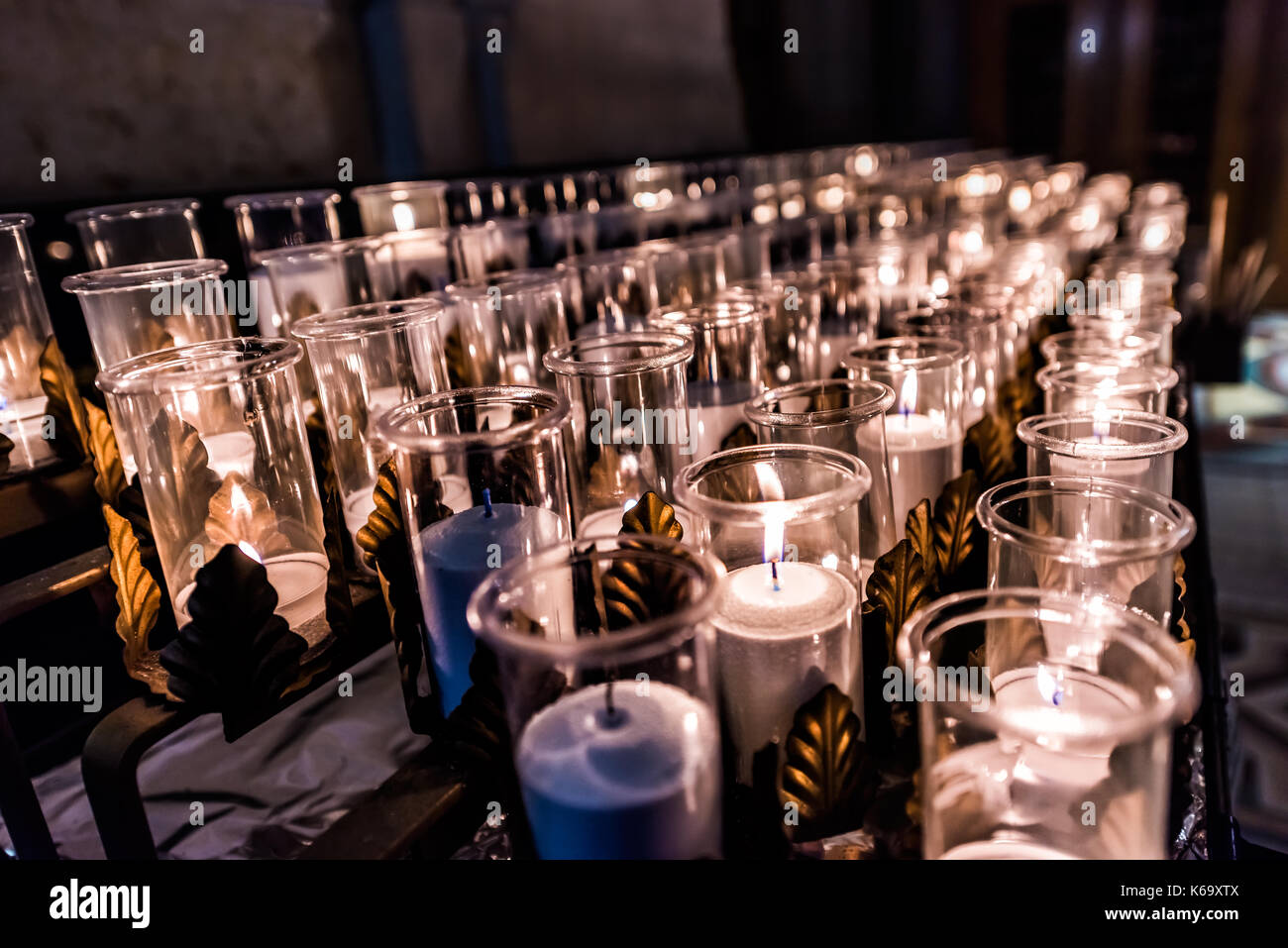 Closeup side pattern of many white religious votive candles with yellow