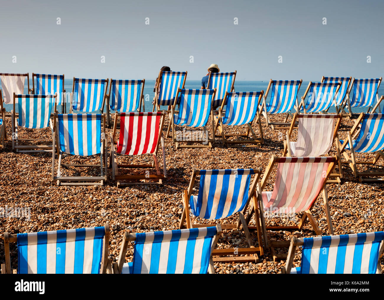 Two People Sitting on Deck Chairs on Brighton Beach Stock Photo - Alamy