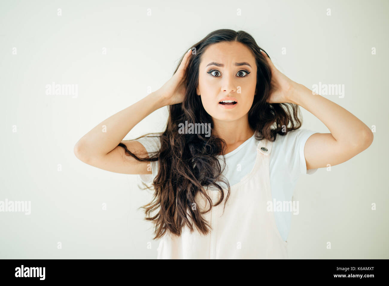 Surprised young woman over at white background Stock Photo - Alamy