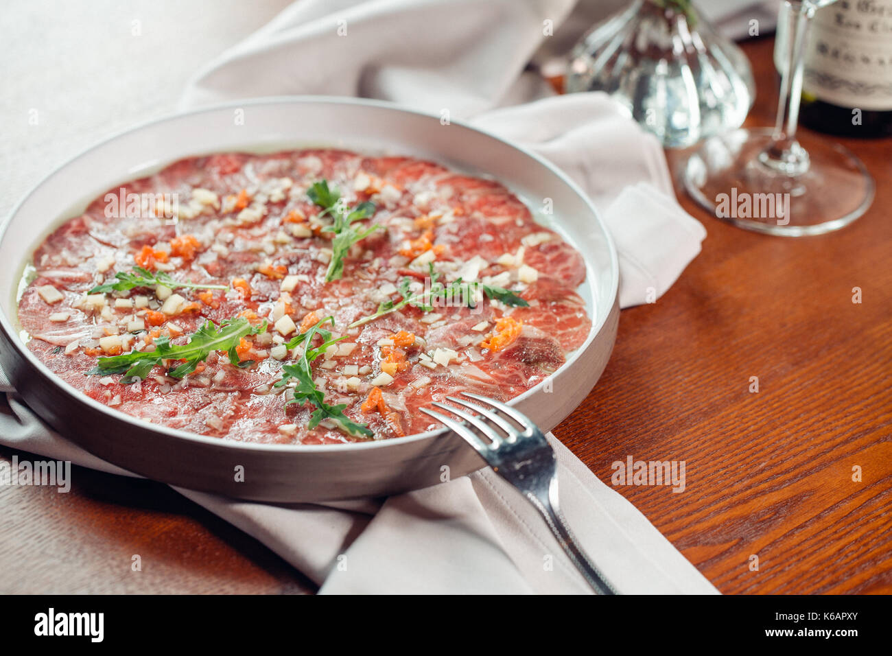 Beef carpaccio with arugula, fork and sauce Stock Photo Alamy