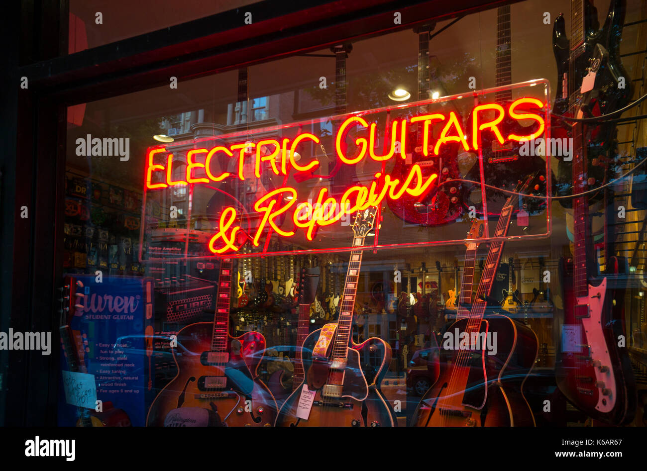 Electric Guitars & Repairs neon sign in store window Stock Photo