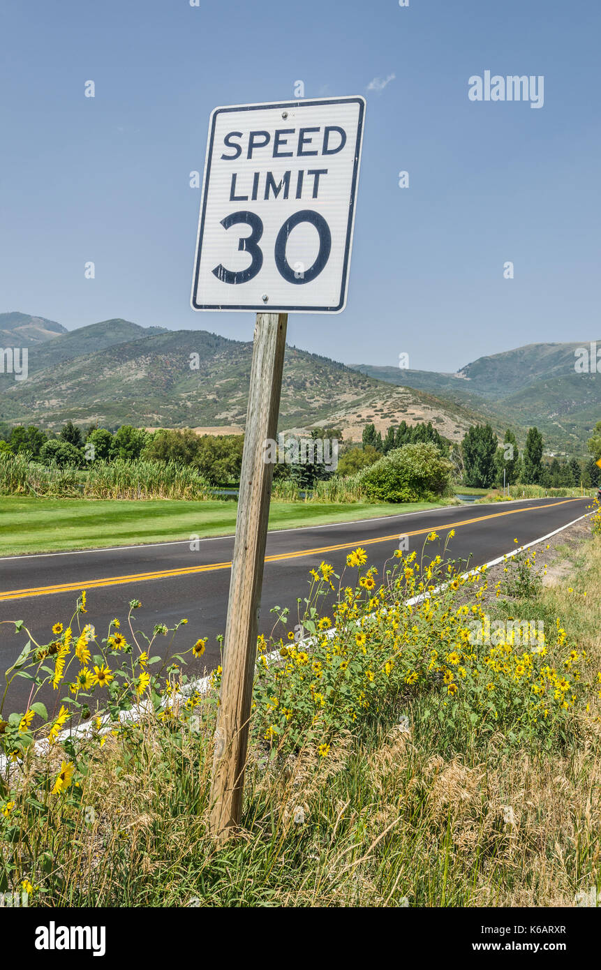 30 mph speed limit sign on a scenic road heading towards the mountains Stock Photo
