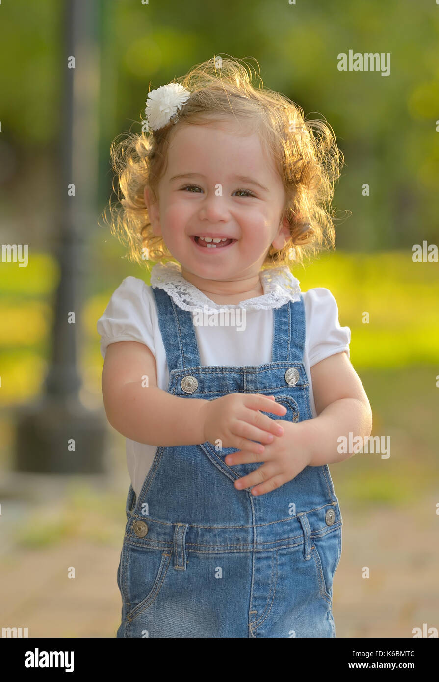 Little girl smiling against the sun Stock Photo