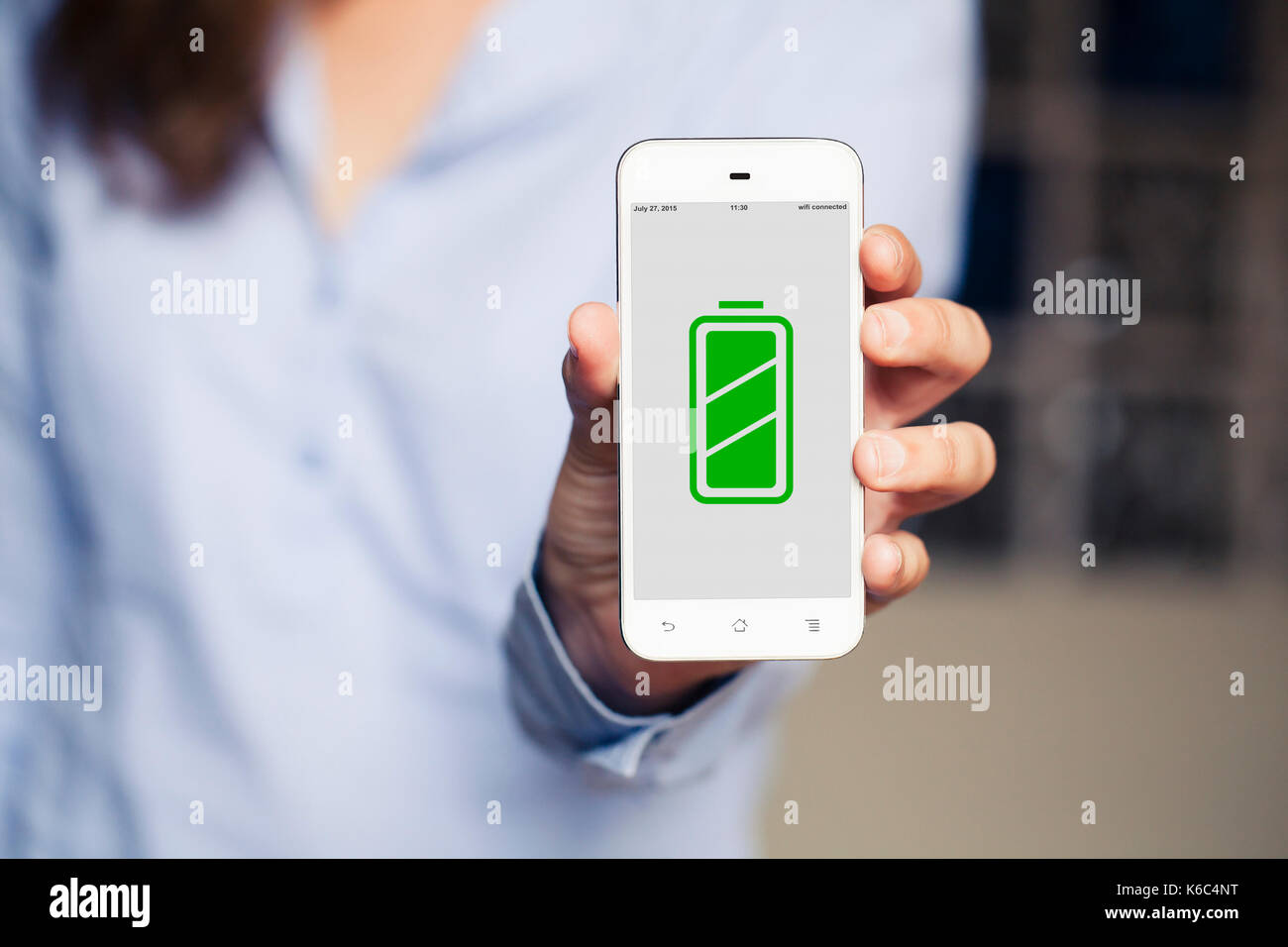 Mobile phone with green full battery charge icon on the screen Stock