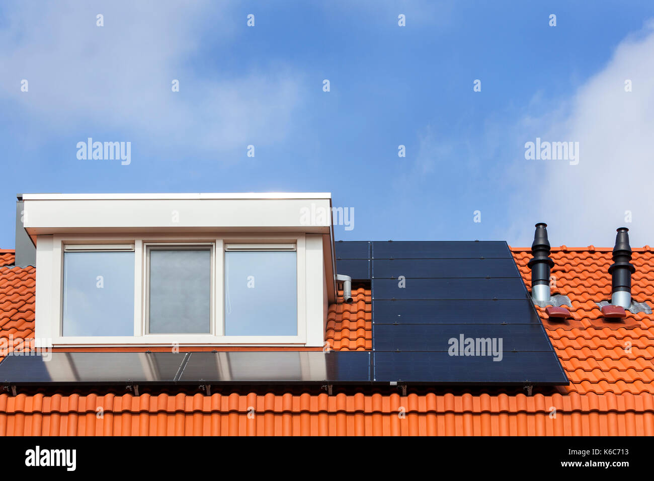 Dormer and solar panels on a red tile roof Stock Photo Alamy