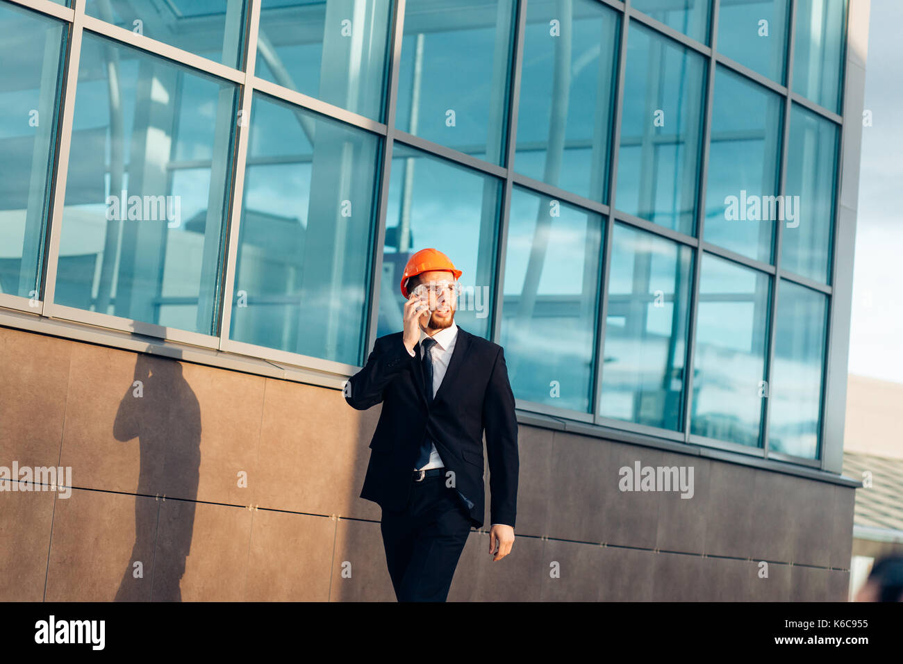 Builder On construction Site Using Mobile Phone Stock Photo