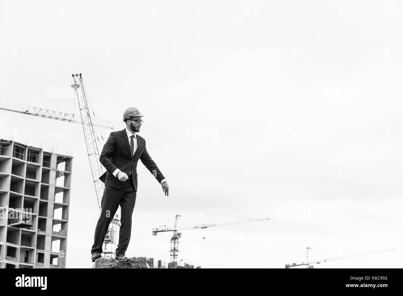 senior builder in hardhats pointing workers outdoors Stock Photo