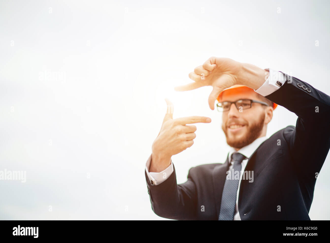 senior builder in hardhats pointing workers outdoors Stock Photo