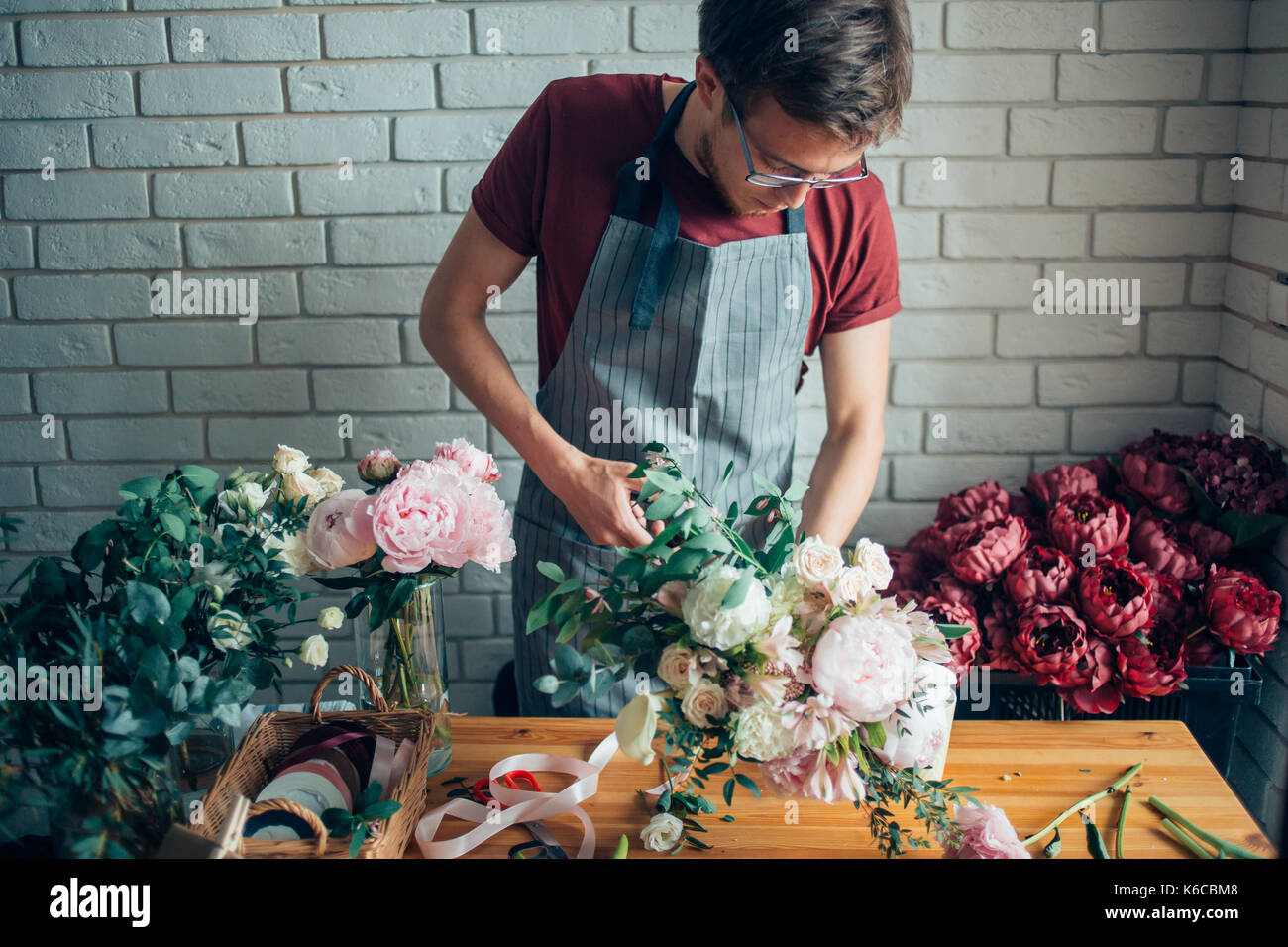 Young male florist working at counter in flower shop Stock Photo