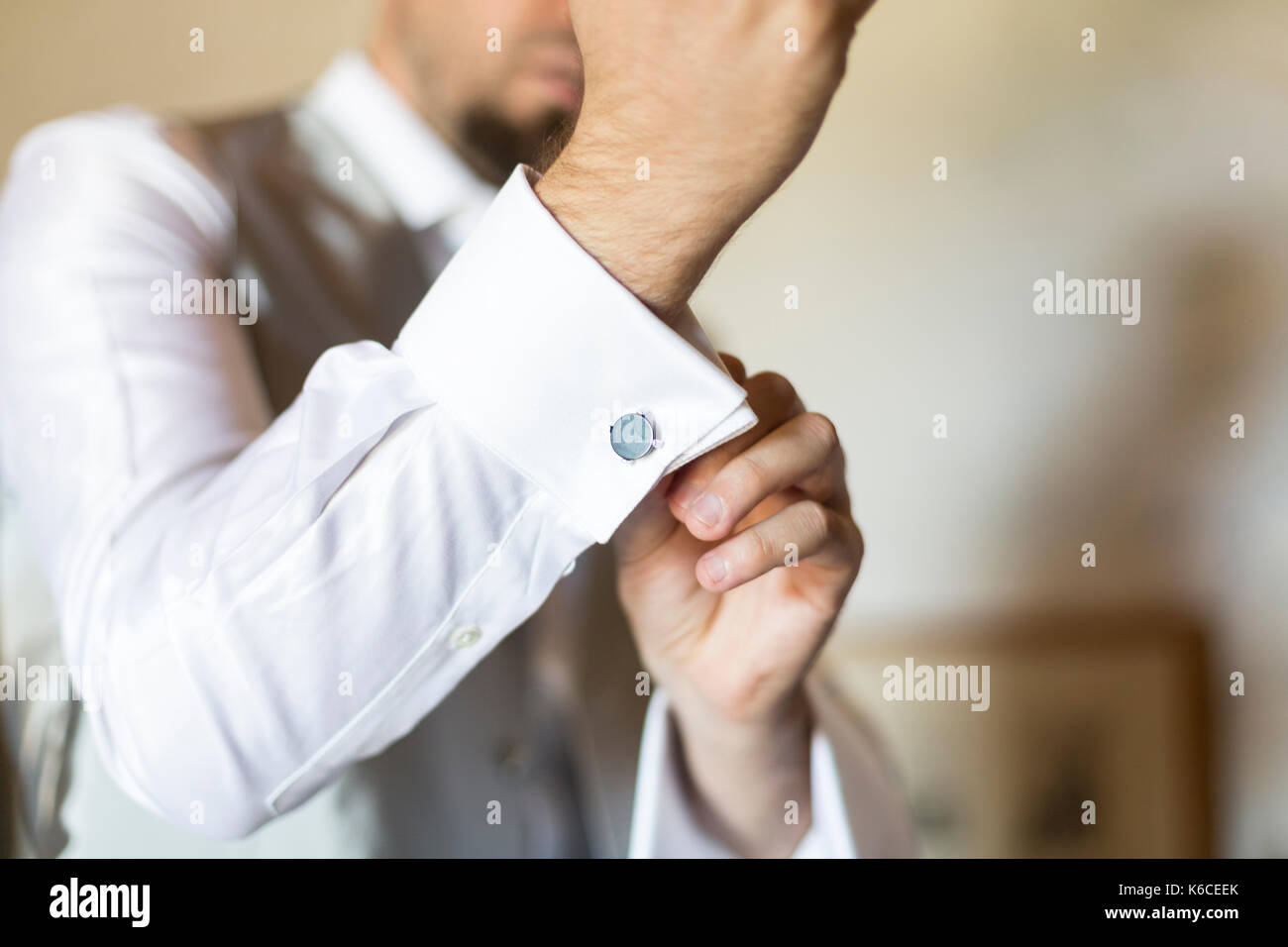 Groom putting the cufflinks on getting ready for the wedding Stock Photo