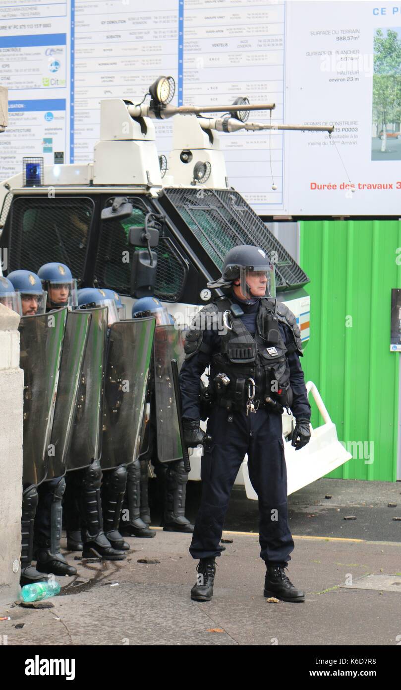 A police officer stands guard as a Loi Travail march passes in central Paris Stock Photo