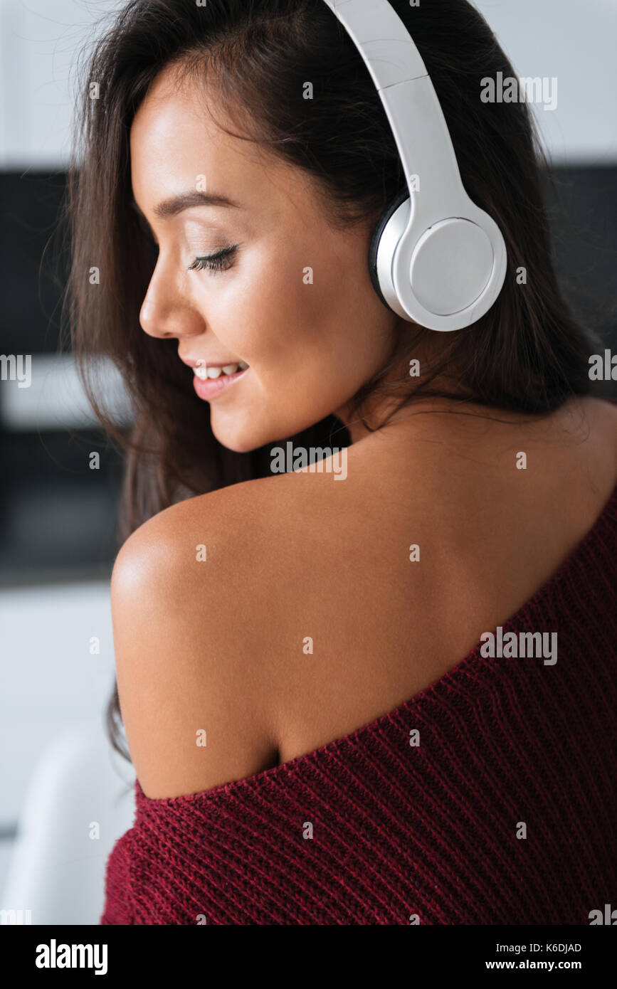 Close up of a young asian woman in headphones enjoys listening to music ...