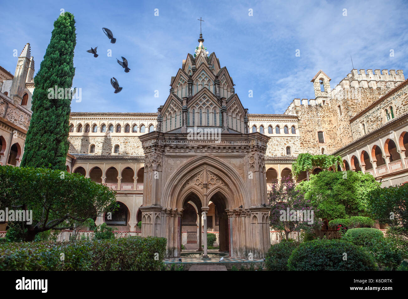 Flying pigeons at mudejar cloister of Guadalupe Monastery. Caceres, Spain Stock Photo