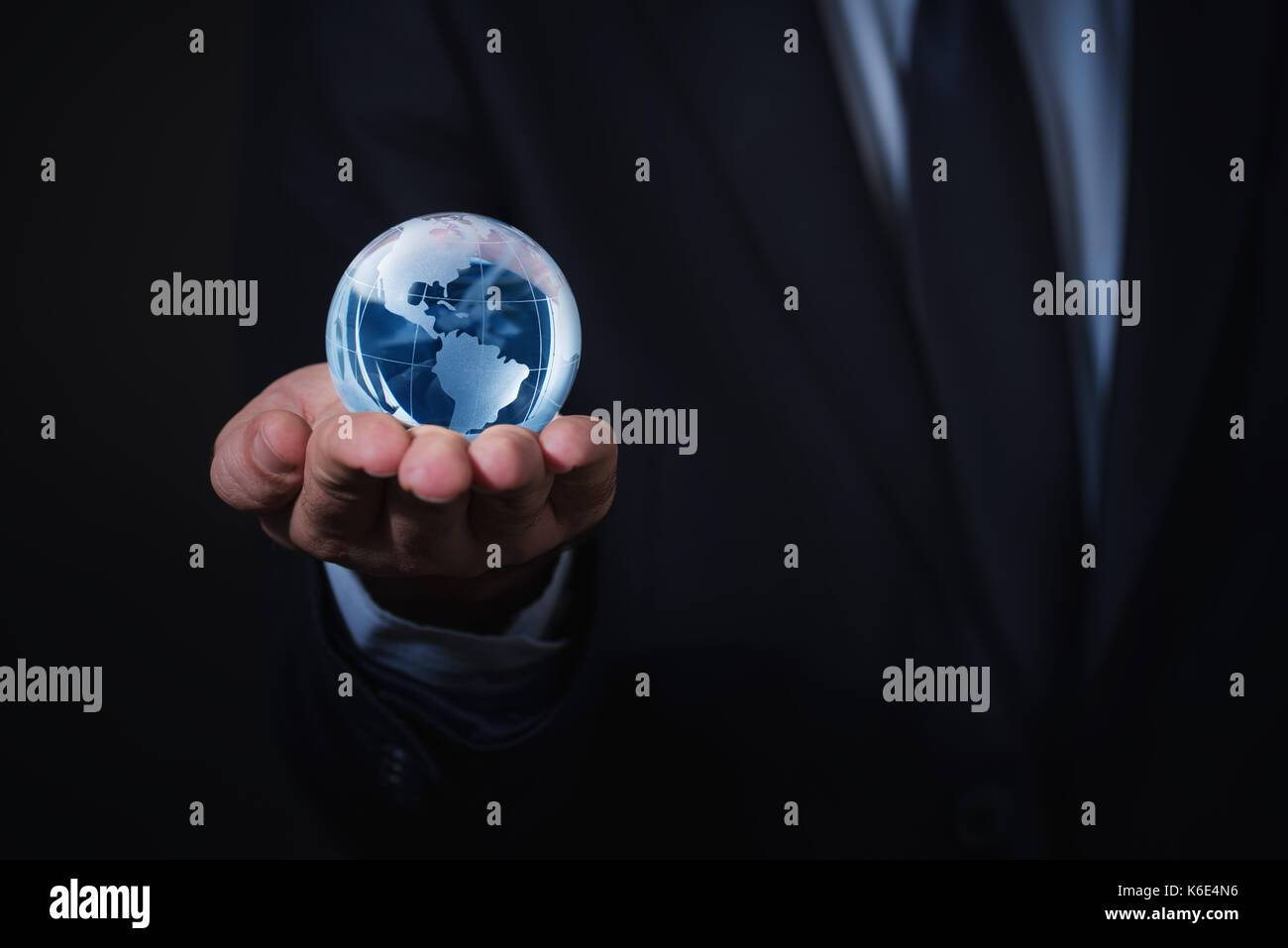 Businessman holds shiny blue Earth in a hand Stock Photo
