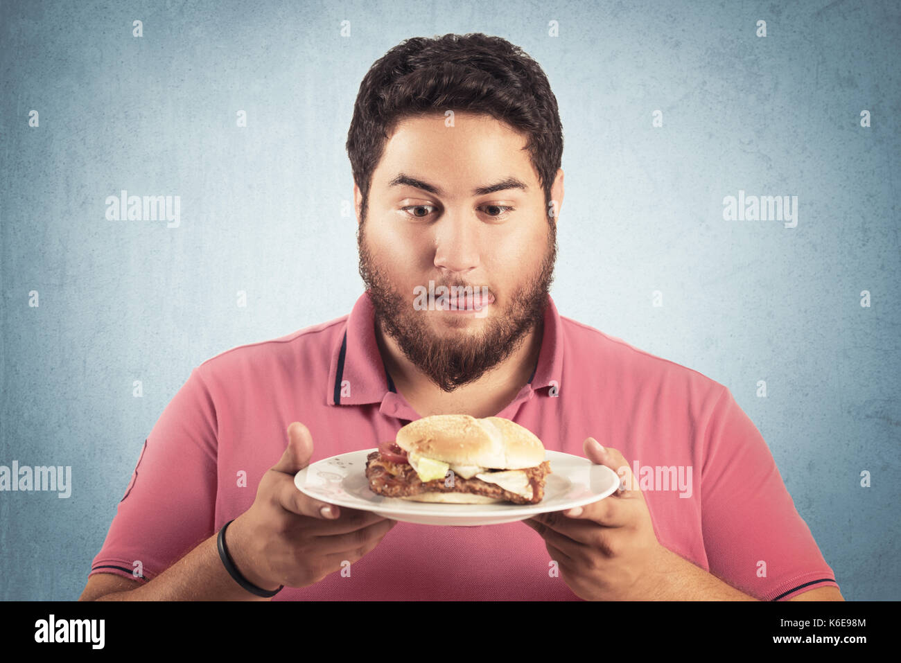 fat and hungry man looking a hamburger Stock Photo