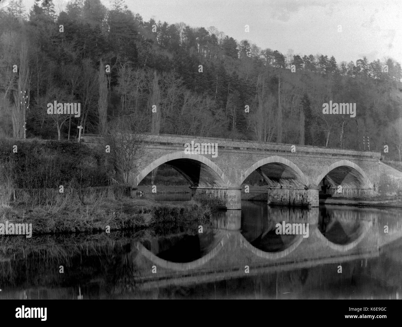 AJAXNETPHOTO. 1891-1910 (APPROX). SAINT-LO, FRANCE. - REFLECTION IN LA VIRE RIVER OF THE RAIL BRIDGE BUISSONNIERE WITH THREE ARCHES AND WOODED LANDSCAPE.PHOTOGRAPHER:UNKNOWN © DIGITAL IMAGE COPYRIGHT AJAX VINTAGE PICTURE LIBRARY SOURCE: AJAX VINTAGE PICTURE LIBRARY COLLECTION REF:AVL FRA 1890 B29X1215 Stock Photo