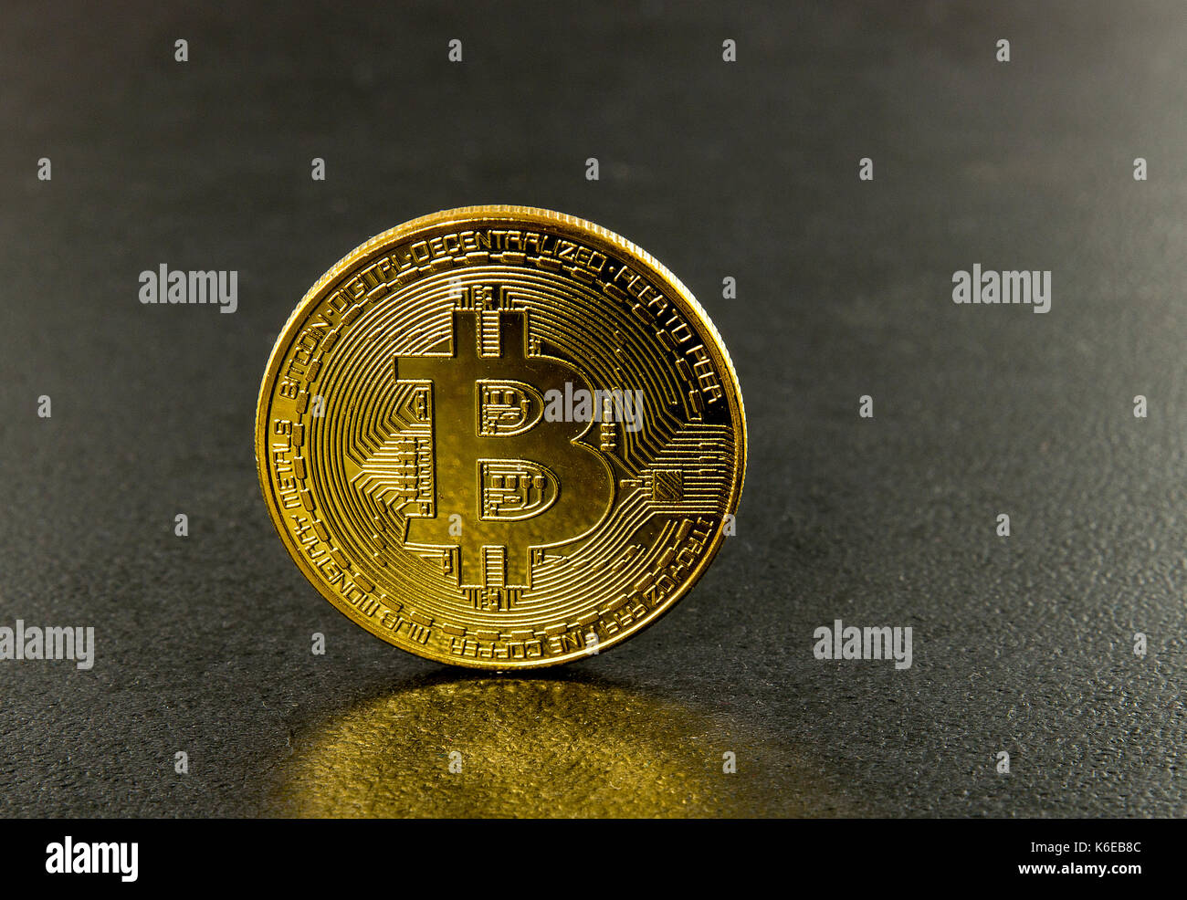 Bitcoins with black background with a single coin facing the camera in sharp focus with shading on the icon letter B on the face of the bit coin Stock Photo