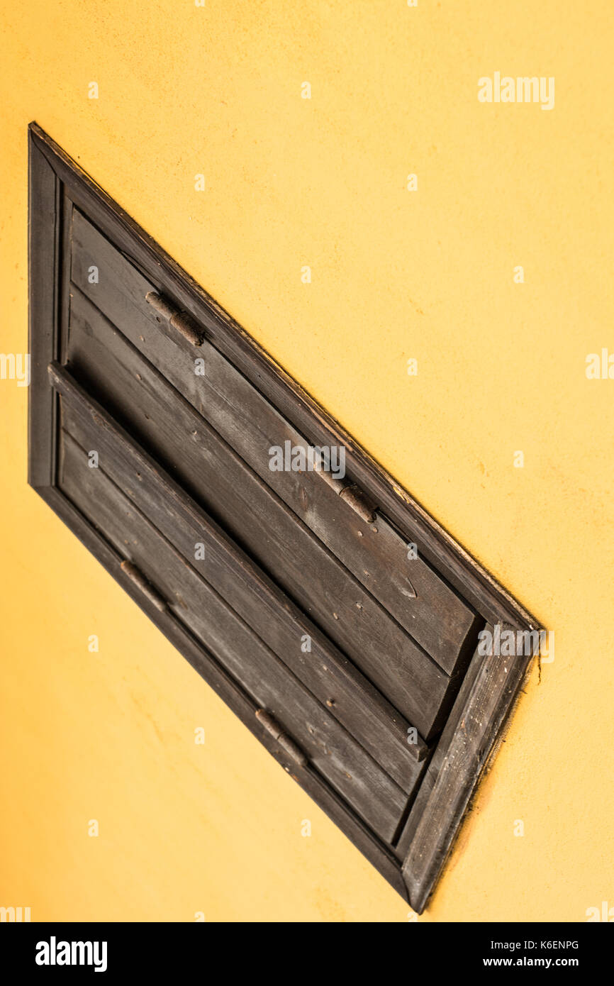 Yellow wall with wooden brown  window. Abstract perspective composition Stock Photo