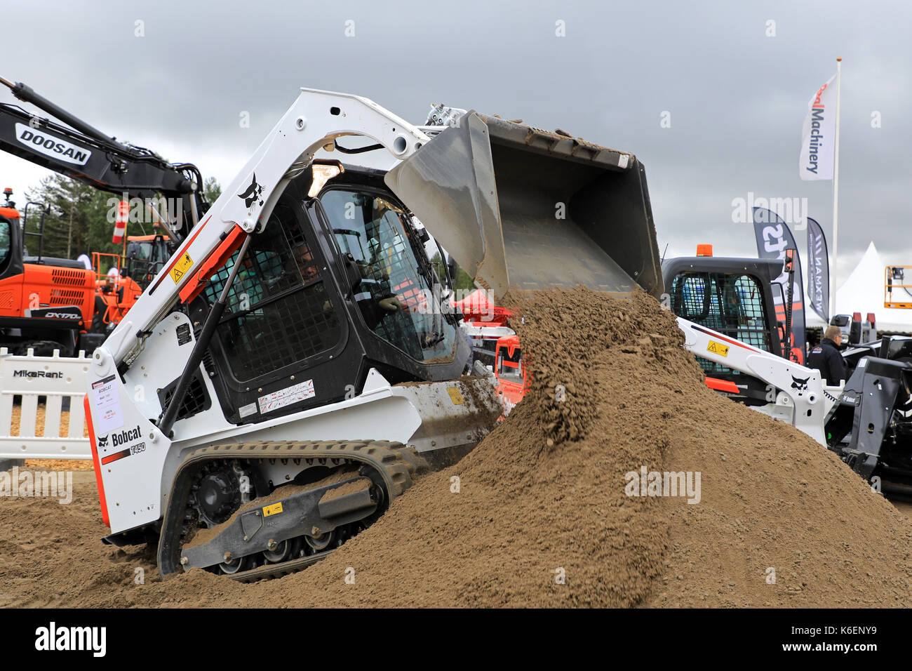 HYVINKAA, FINLAND - SEPTEMBER 8, 2017: Operator unloads sand with Bobcat T450 Compact Track Loader on work site on Maxpo 2017. Stock Photo