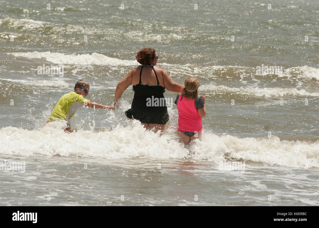 FAMILY PLAYING IN GULF OF MEXICO WAVES, BOLIVAR PENINSULA, TEXAS Stock Photo