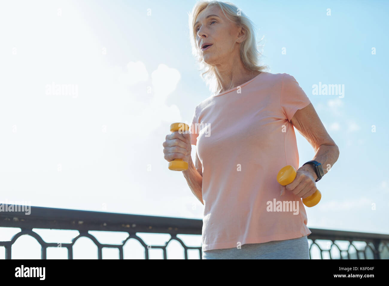 Athletic woman running with dumbbells Stock Photo