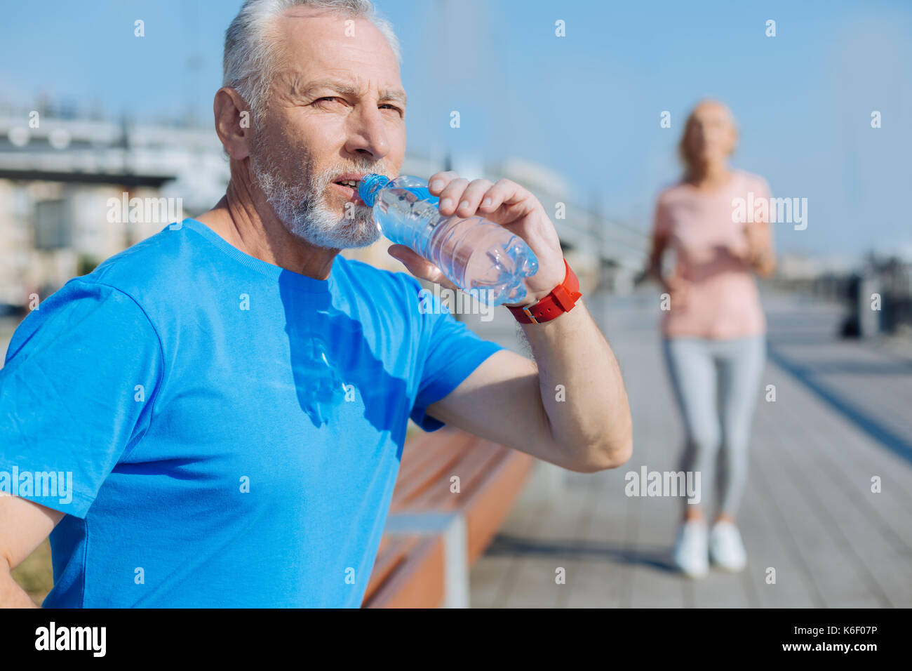 Athletic man drinking water after morning run Stock Photo