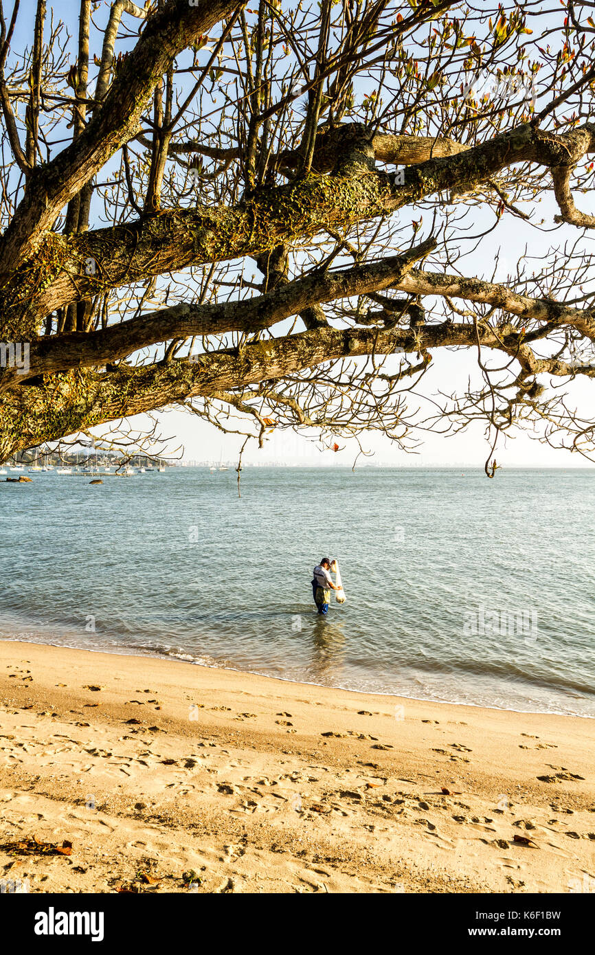 Fisherman fishing with fishing net in Santo Antonio de Lisboa Beach. Florianopolis, Santa Catarina, Brazil. Stock Photo