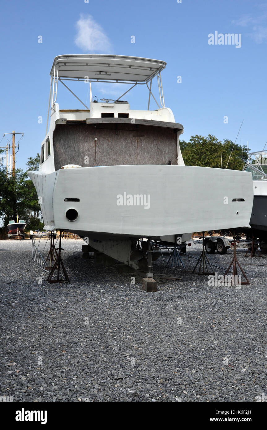 Rear of a White Fishing Boat Boarded Up at Dry Dock Stock Photo