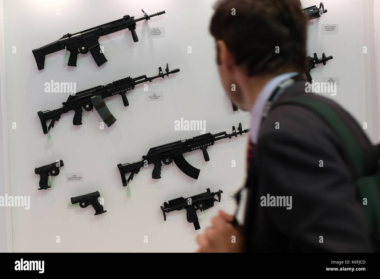 A visitor looks at weapons during the Defence Systems and Equipment International arms fair at the ExCel centre in London. Stock Photo