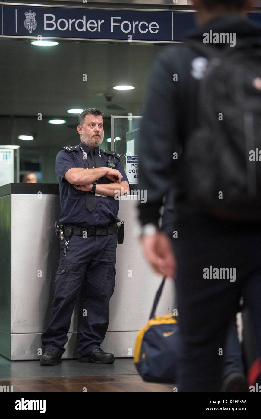 Embargoed to 1800 Tuesday September 12 A UK Border Force officer watches  over passengers arriving from Paris on the Eurostar as officers from the  Metropolitan Police Service, British Transport Police, Kent Police