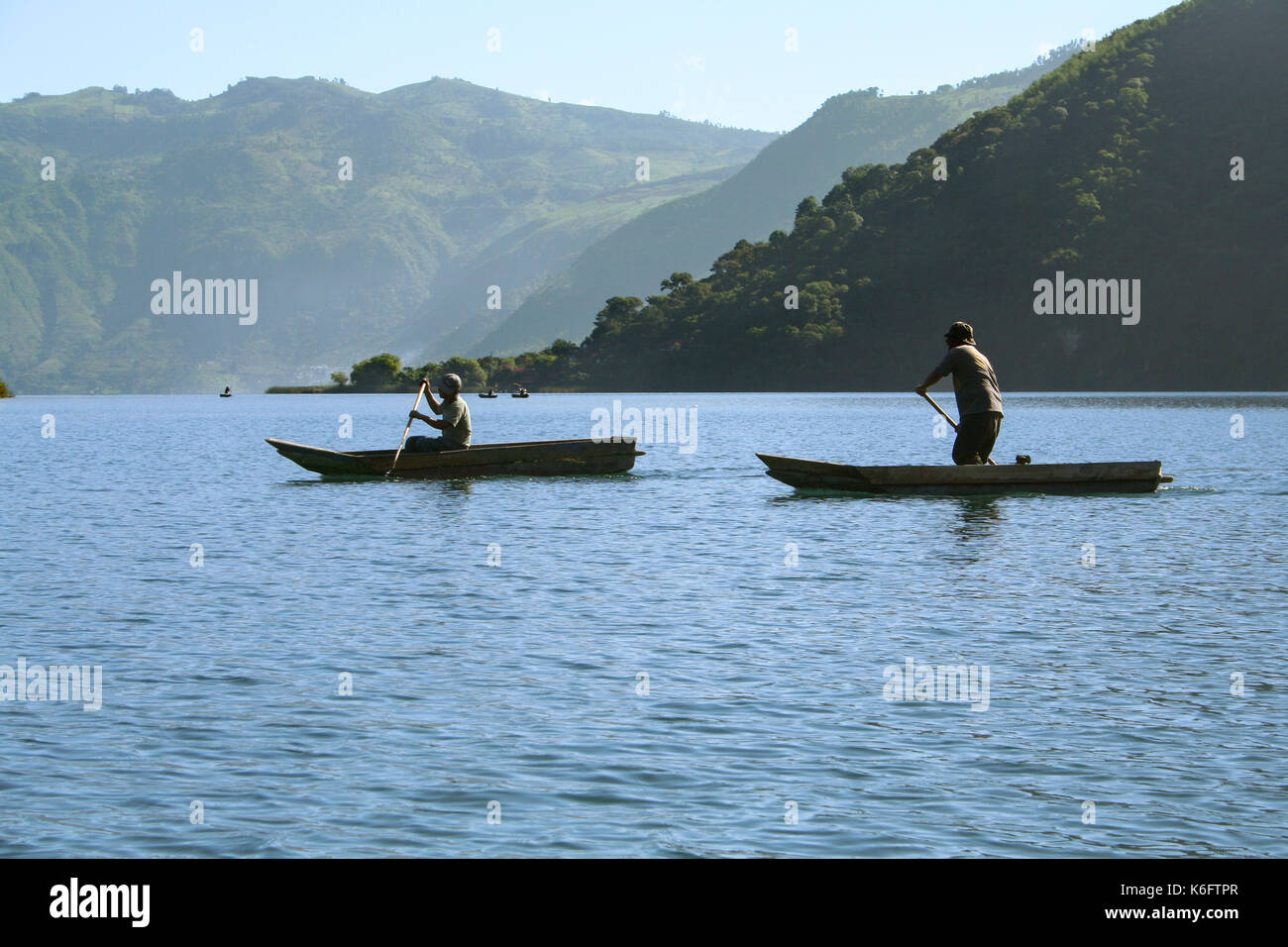 Two men in canoes paddling on a fishing adventure on Lake Atitln, Guatemala Stock Photo