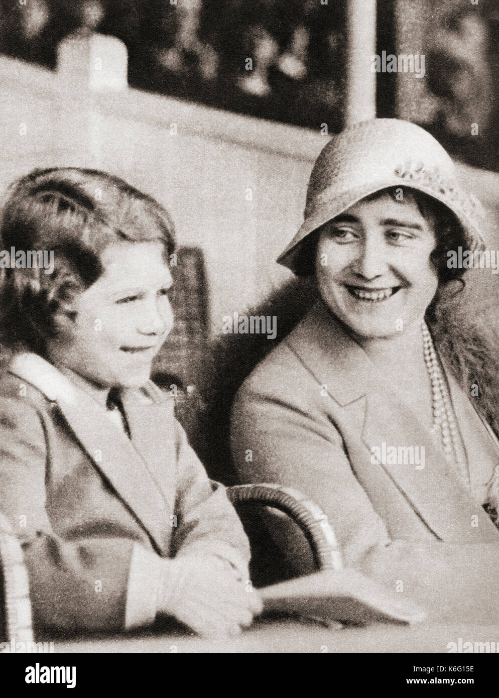 Princess Elizabeth of York with her mother the Duchess of York at the rehearsal of the Aldershot Tattoo in 1932.  Princess Elizabeth of York, future Elizabeth II,1926 - 2022. Queen of the United Kingdom.  Duchess of York, future Queen Elizabeth, The Queen Mother.  Elizabeth Angela Marguerite Bowes-Lyon, 1900 – 2002.  Wife of King George VI and mother of Queen Elizabeth II.  From The Coronation Book of King George VI and Queen Elizabeth, published 1937. Stock Photo