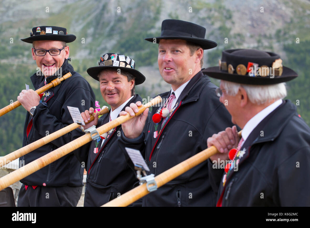 Four traditionally dressed locals with alphorns, Zermatt, Valais, Switzerland Stock Photo