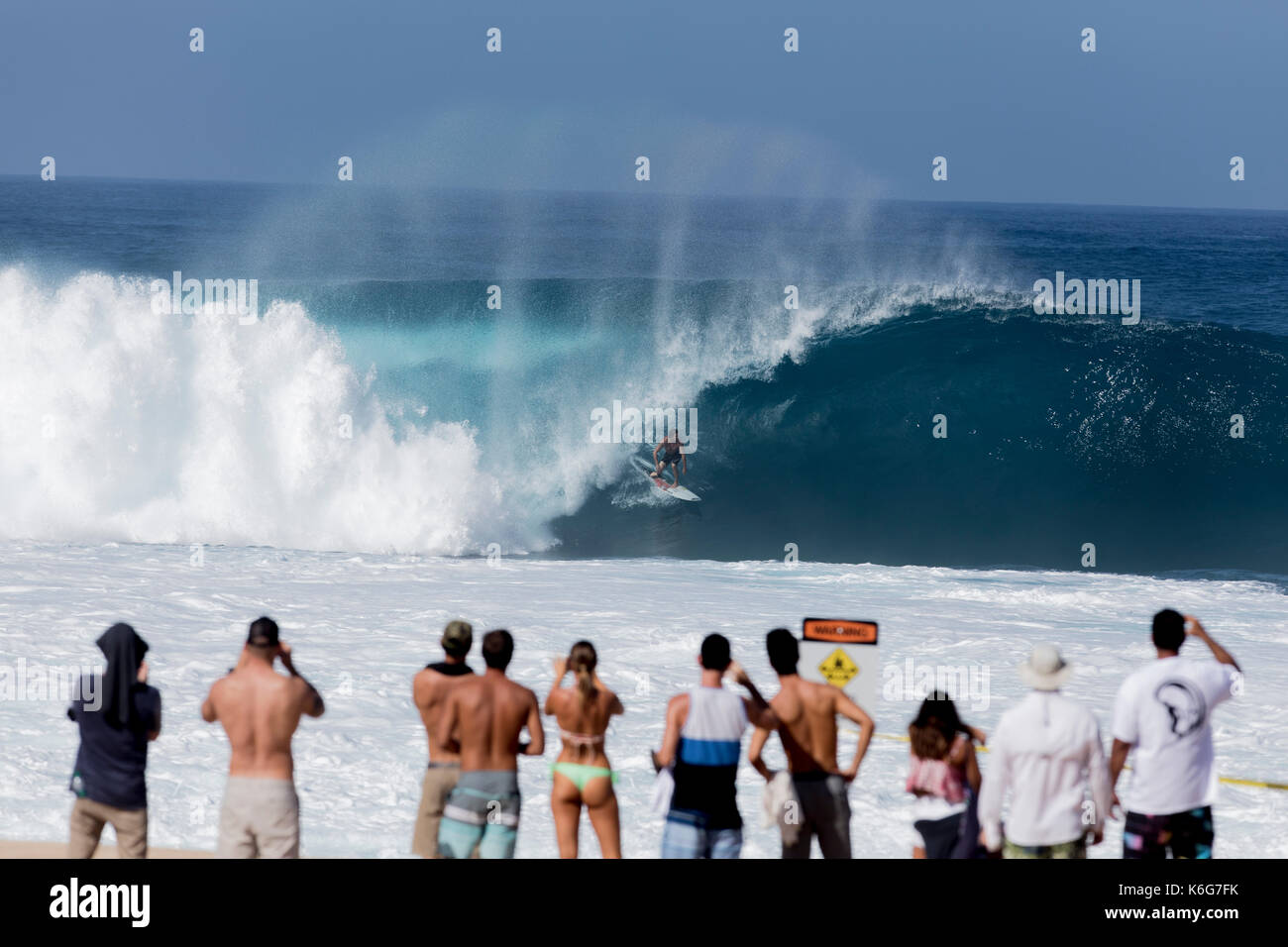 People watching surfer riding wave at Banzai Pipeline, Oahu, Hawaii, USA Stock Photo