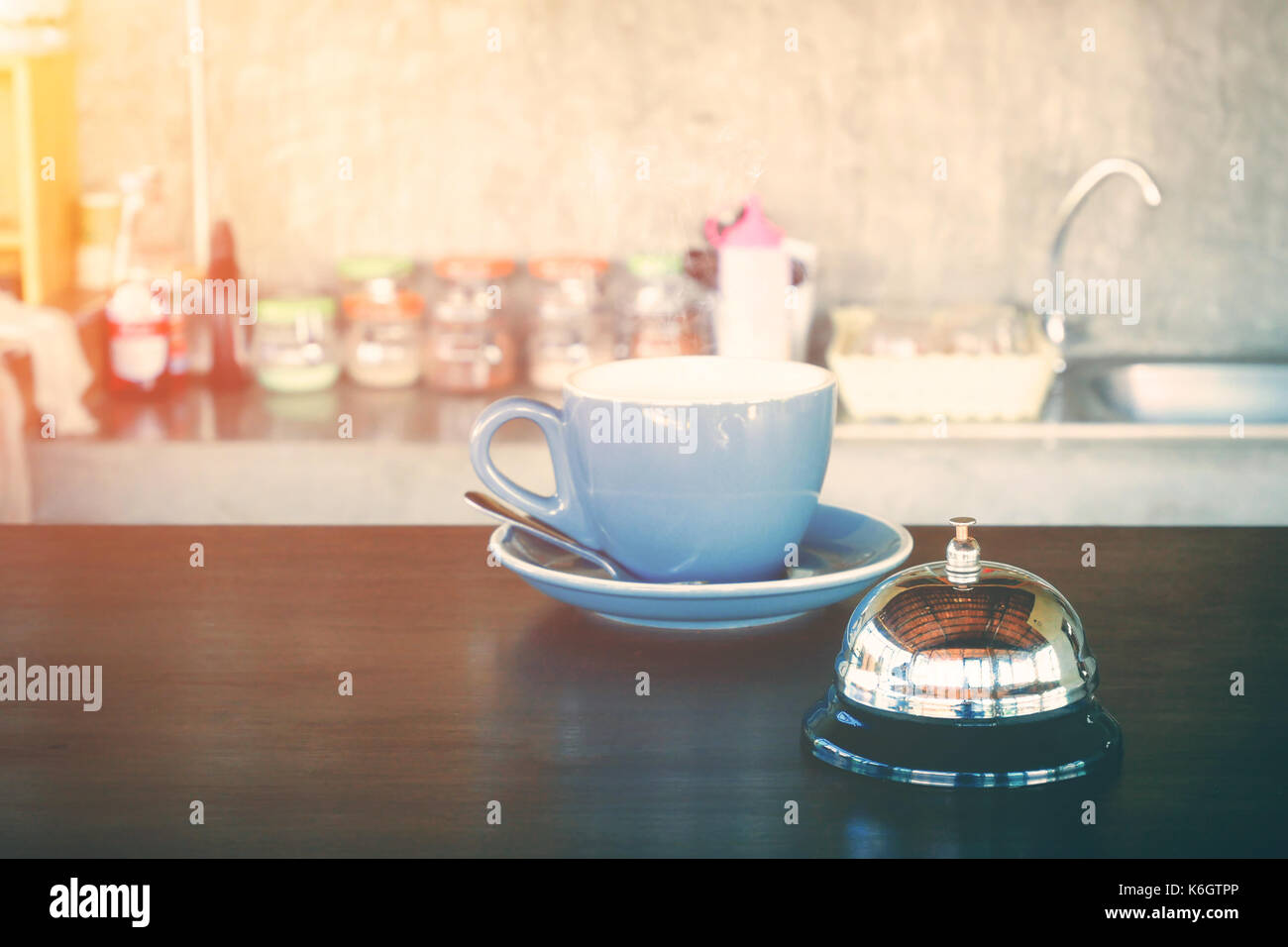 bell and hot coffee cup on coffee shop counter for alert or wark up concept Stock Photo