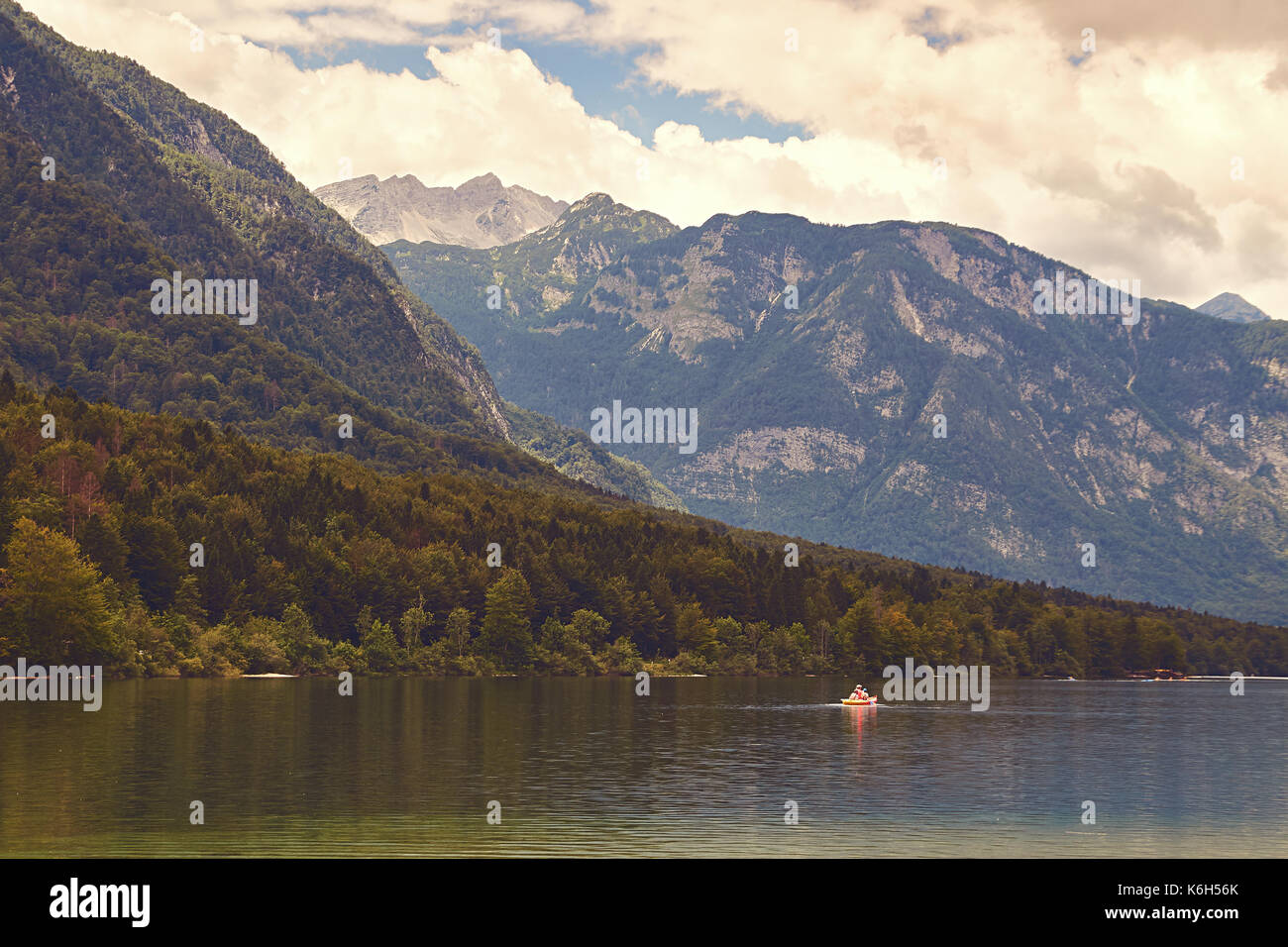 View of lake Bohinj with the boat sailing across it Stock Photo