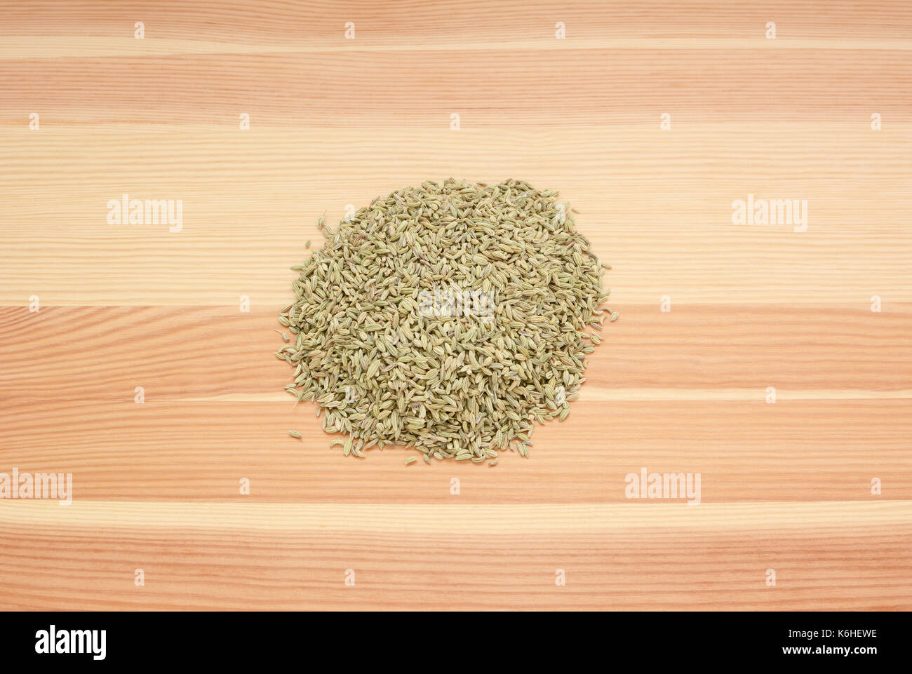 Heap of dried fennel seeds on a wooden background, pine wood grain Stock Photo