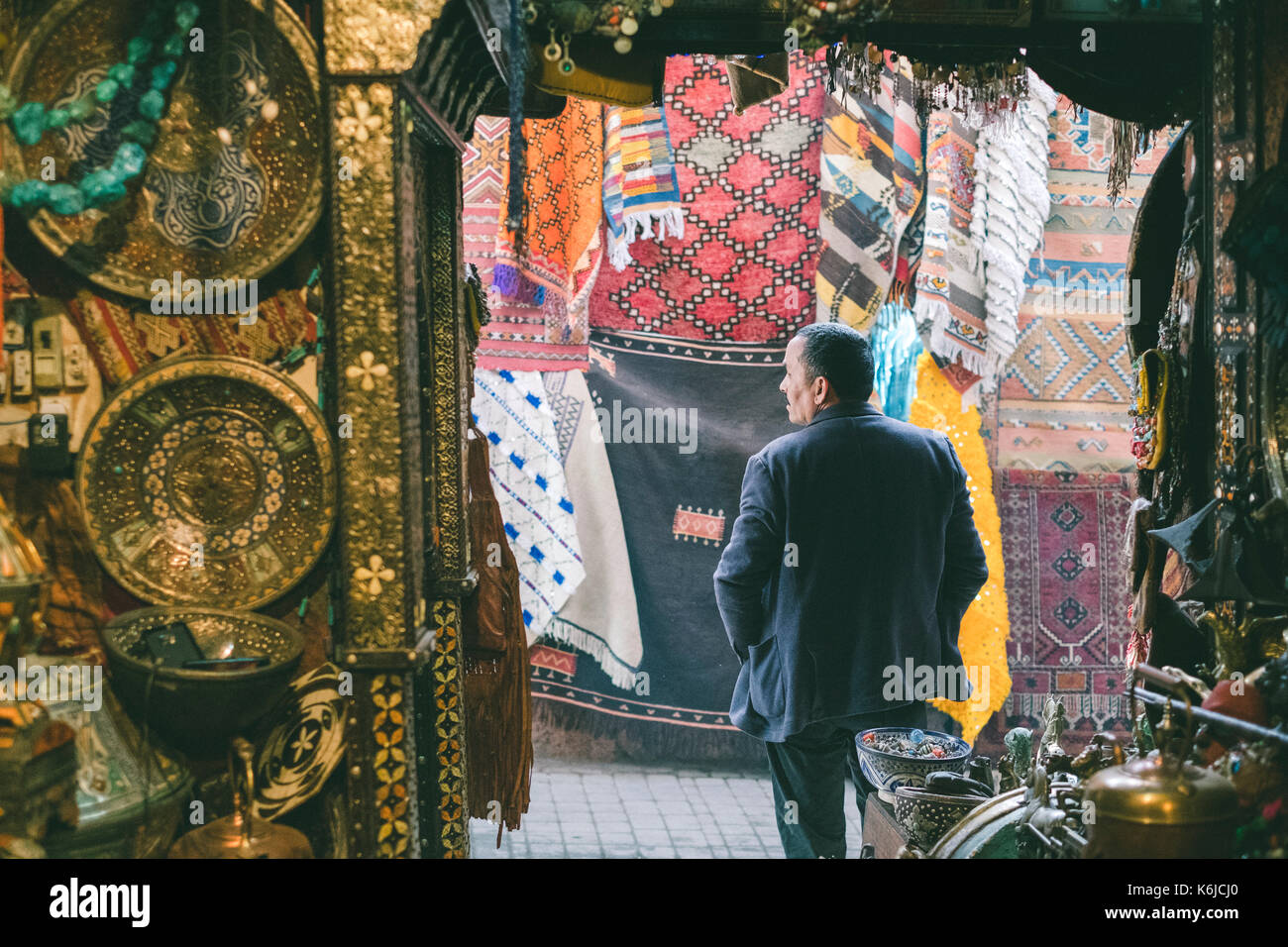 Shopkeeper standing at door of souvenir shop, Medina, Marrakesh, Morocco Stock Photo