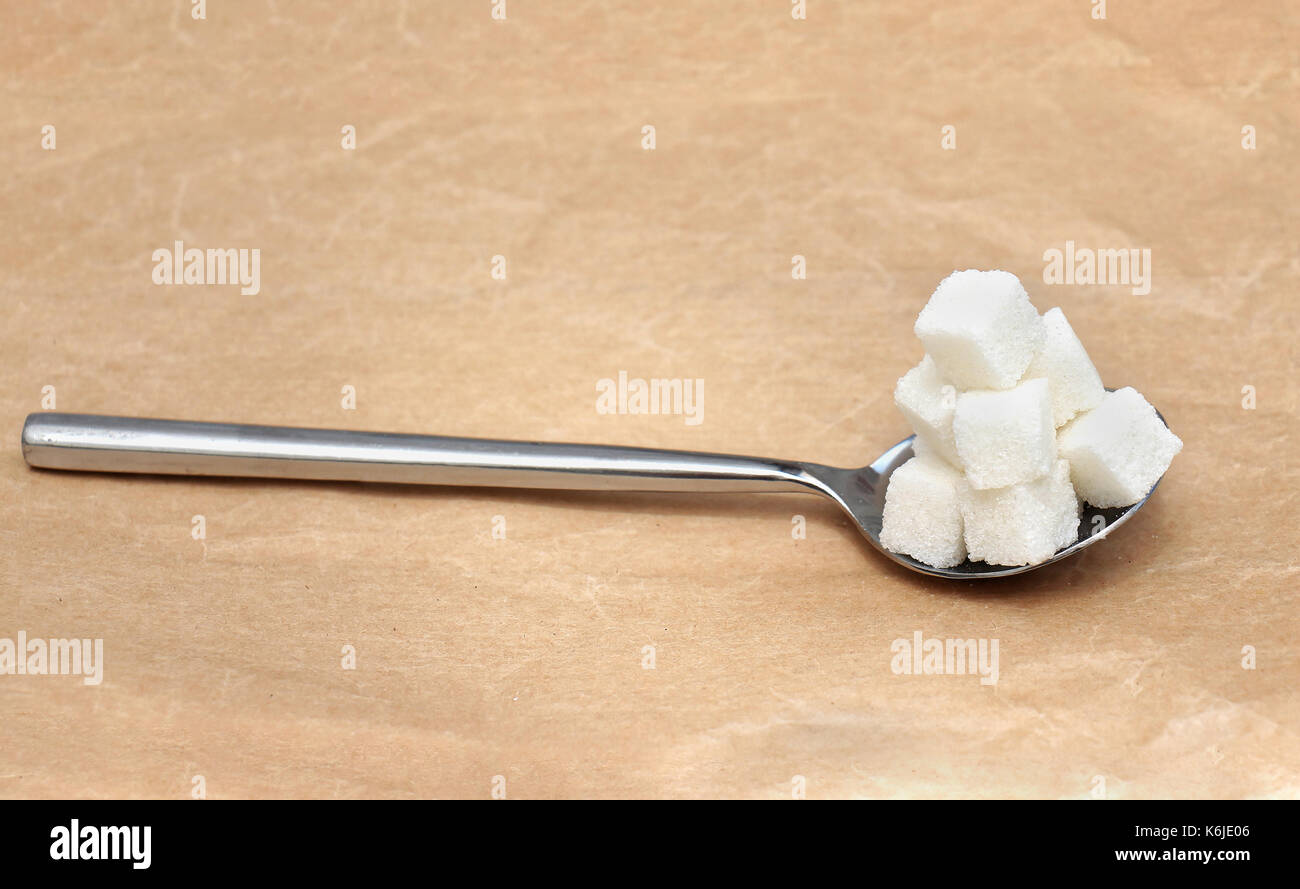 Spoon full with white sugar cubes pile Stock Photo