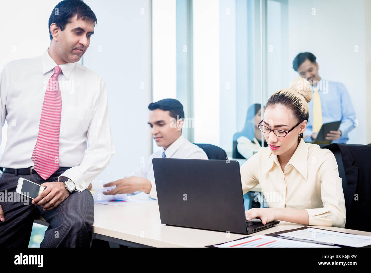 Boss supervising his employees in office Stock Photo