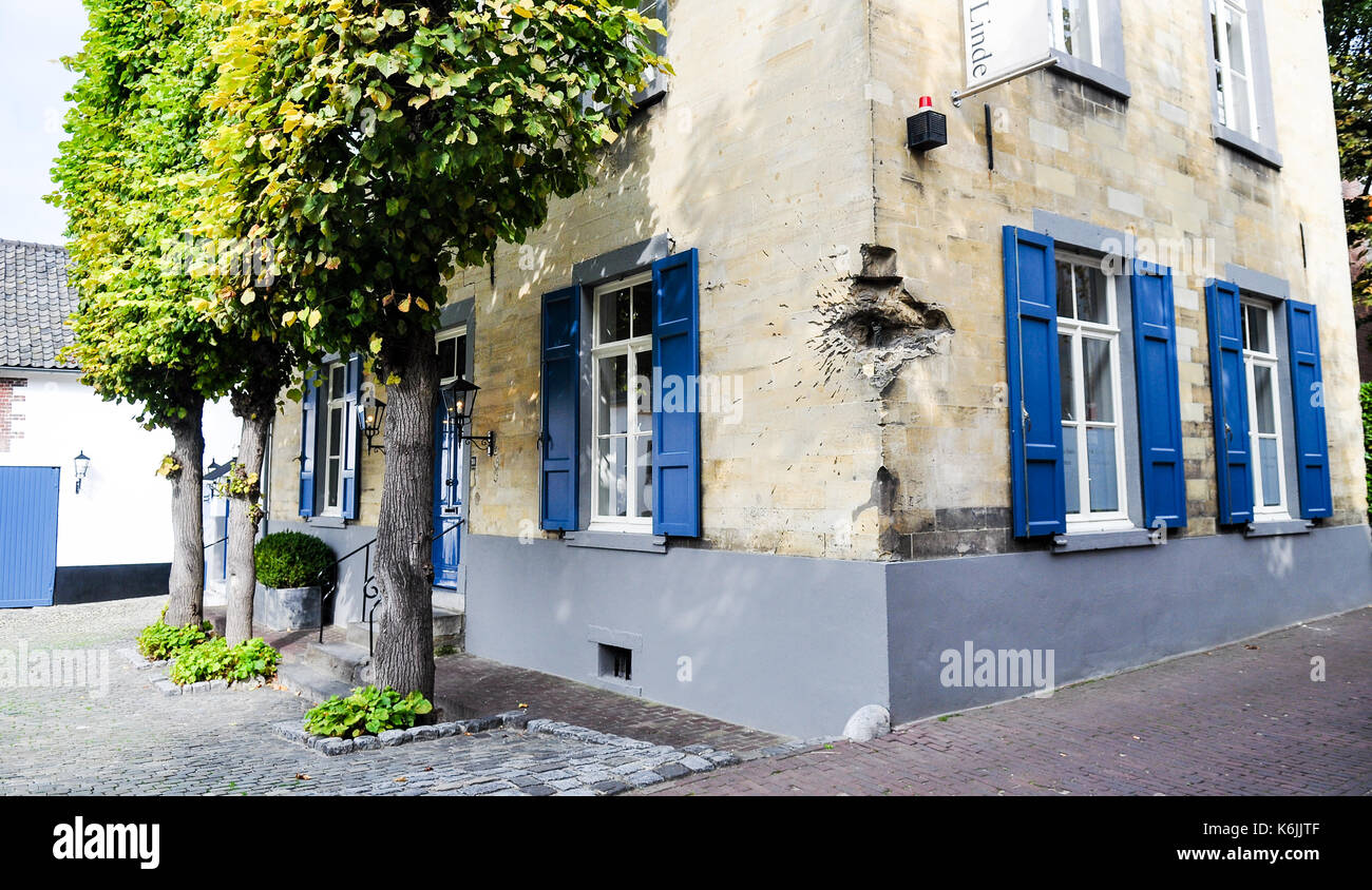 A house in Valkenburg, in the southern Netherlands province of Limburg, preserves damage from a bomb blast or anti-tank bomb, likely dating from the t Stock Photo