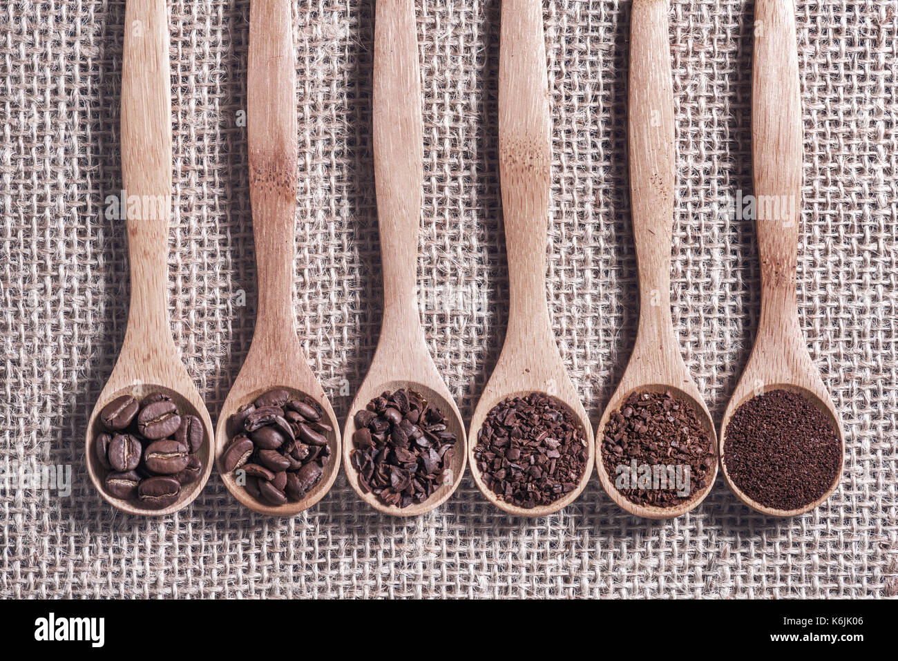 Roasted coffee beans. Spoons with coffee showing the grinding stages. Stock Photo