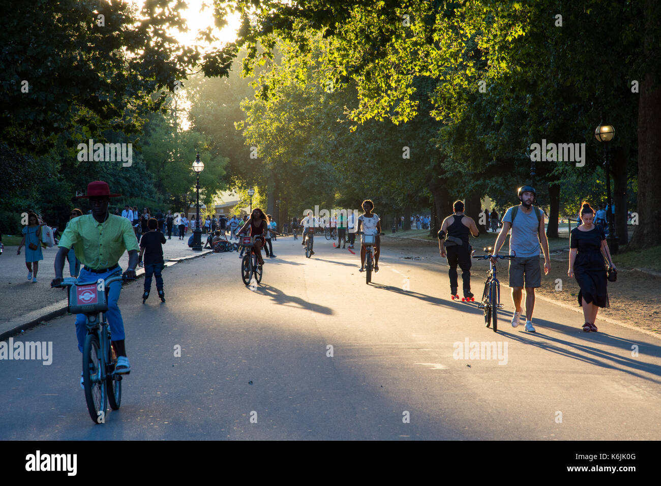 London, England, UK - August 23, 2016: Tourists ride 'Boris Bike' city hire bikes in London's Hyde Park at sunset. Stock Photo