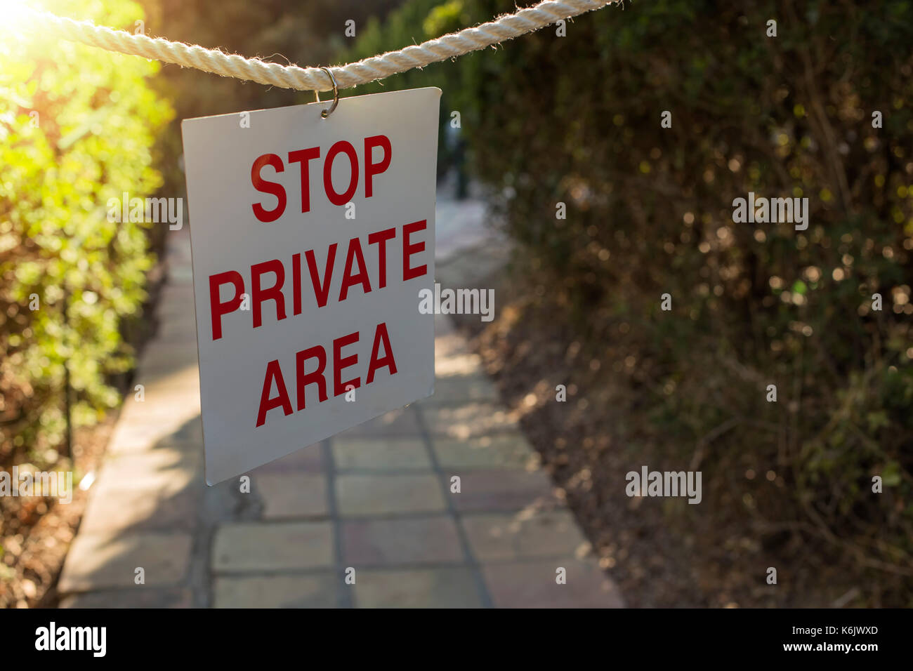 Sign says STOP Private AREA hanging on the rope Stock Photo