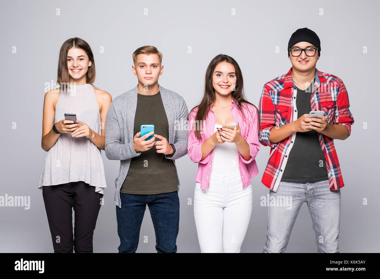 Fours Friends using gadget technology Phone isolated on grey Stock Photo