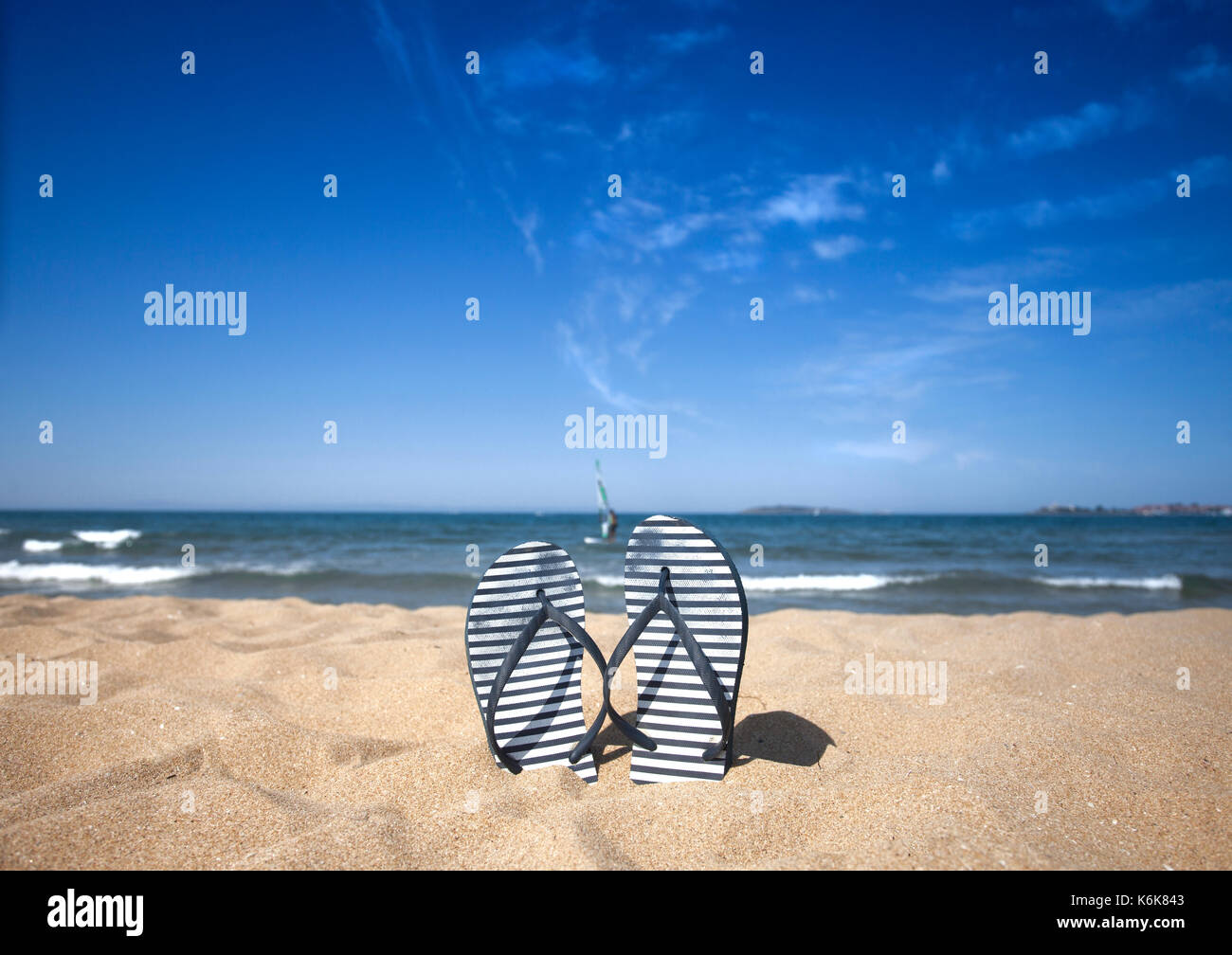 Blue sandal flip flop on the sand beach with blue sea and sky ...